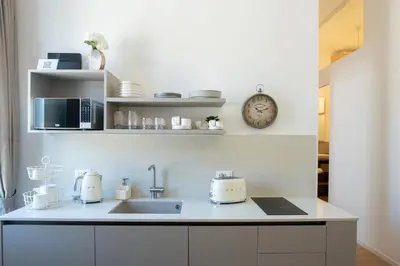 a kitchen counter with a sink and a clock at LV Vatican boutique apartment in Rome