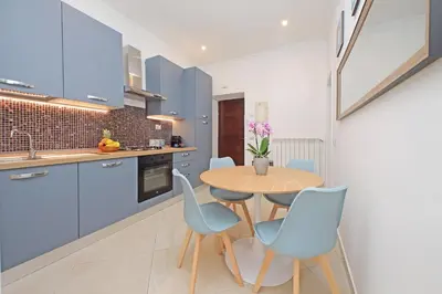 a kitchen with blue cabinets and a sink at Alba Home Re Di Roma in Rome