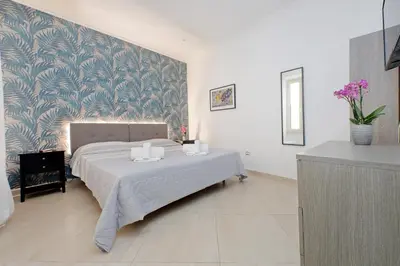 a bedroom with a bed with a blue and white wallpaper at Alba Home Re Di Roma in Rome