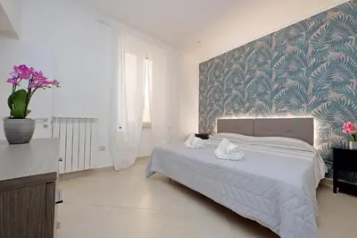 a curtain with a mural of plants on a wall at Alba Home Re Di Roma in Rome
