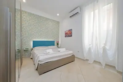 a bedroom with a bed and a blue wall at Alba Home Re Di Roma in Rome