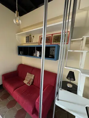 a living room with a red couch and a staircase at Casa Lella al Borgo Pio, a pochi passi da San Pietro in Rome