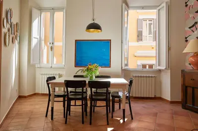 a dining room with a table and chairs at TrastevereHome - Elegant Home Near Navona Square in Rome