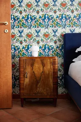 a bedroom with a bed and a wooden cabinet with a cup on it at TrastevereHome - Elegant Home Near Navona Square in Rome