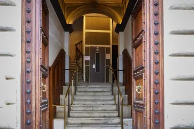 an entrance to a building with wooden doors and stairs at TrastevereHome - Elegant Home Near Navona Square in Rome