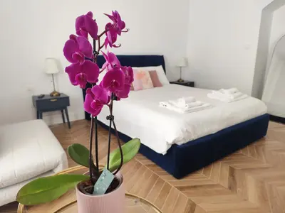 a room with a bed and a vase with purple flowers at Vatican Eco Suite in Rome