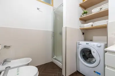 a bathroom with a washing machine and a toilet at 5 Minutes to St Peter - Luxury Stay in Rome