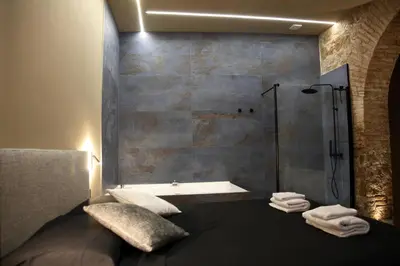 a bathroom with a tub and a shower with towels at Unique Trastevere in Rome