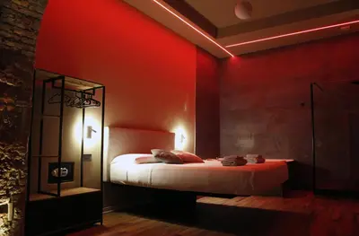 a bedroom with a bed with a red wall at Unique Trastevere in Rome
