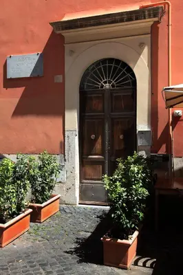 a door to a building with two potted plants in front at Unique Trastevere in Rome