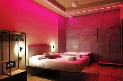 a pink room with a bed and a shower at Unique Trastevere in Rome