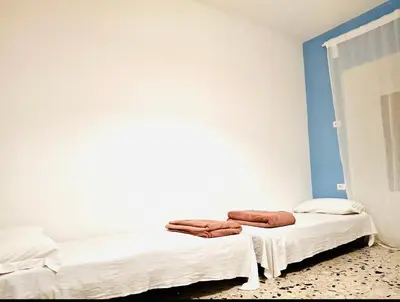 two beds in a room with blue and white walls at Baraka 24 in Rome
