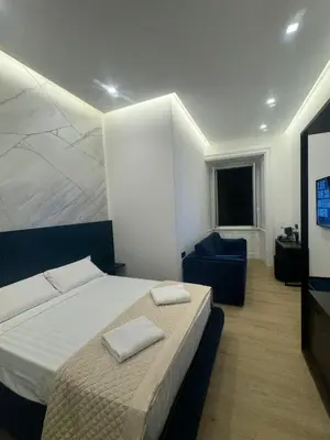 a bedroom with a large bed and a blue couch at santa maria maggiore luxury guest house in Rome