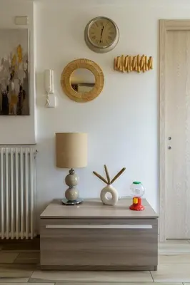 a table with a lamp and a clock on the wall at Ginevra Apartment in Rome in Rome