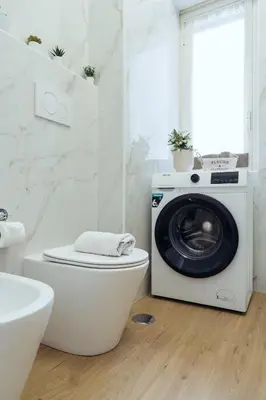a washing machine sitting on top of a toilet in a bathroom at Domus Clelia in Rome