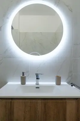 a bathroom with a sink with a round mirror at Domus Clelia in Rome