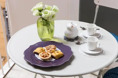 a table with a plate of pastries and a vase with flowers at Al Centro di Roma - Vaticano in Rome