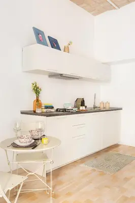 a white kitchen with a table and a counter at Al Centro di Roma - Vaticano in Rome