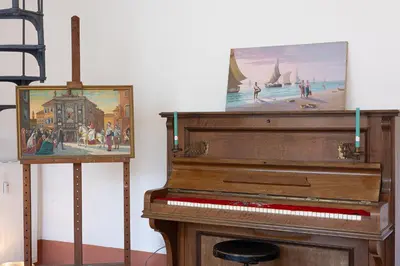 a piano next to a painting of a beach at Amazing Penthouse Vaticano in Rome
