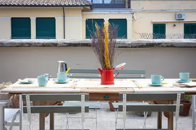 a table with a red watering can on a patio at Amazing Penthouse Vaticano in Rome