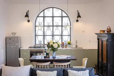 a kitchen with a table and chairs and a kitchen with a window at Amazing Penthouse Vaticano in Rome