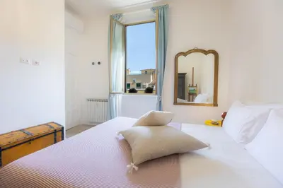 a bedroom with a bed with a mirror and a window at Amazing Penthouse Vaticano in Rome