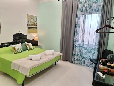 a bedroom with a green bed and a window at Re di Roma nice rooms in Rome