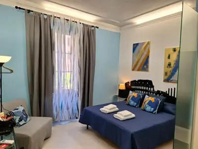a blue bedroom with a bed and a window at Re di Roma nice rooms in Rome