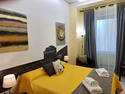 a bedroom with a yellow bed with towels on it at Re di Roma nice rooms in Rome