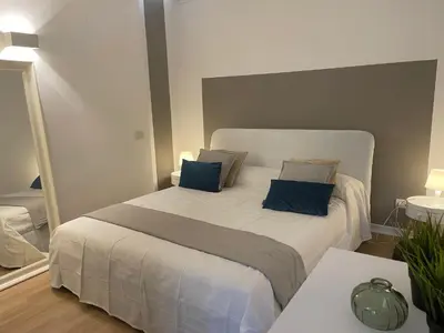 a bedroom with a large bed with blue pillows at La Casetta di Ponte Milvio con parcheggio in Rome