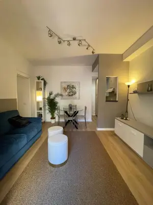a living room with a blue couch and a table at La Casetta di Ponte Milvio con parcheggio in Rome