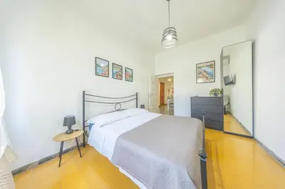 a white bedroom with a bed and a mirror at Casa Piazza Lodi in Rome