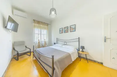 a bedroom with a bed and a chair and a television at Casa Piazza Lodi in Rome