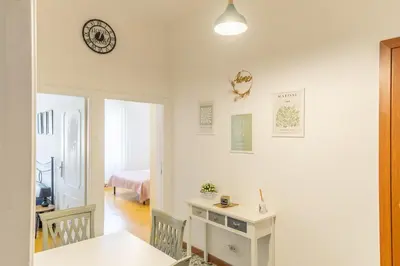 a white room with a table and a clock on the wall at Casa Piazza Lodi in Rome