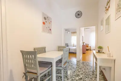 a dining room with a white table and chairs at Casa Piazza Lodi in Rome
