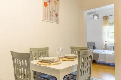 a dining room with a white table and chairs at Casa Piazza Lodi in Rome