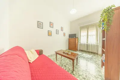 a living room with a red couch and a table at Casa Piazza Lodi in Rome