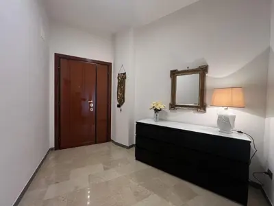 a room with a dresser with a lamp and a mirror at Luxury apartment San Giovanni in Rome