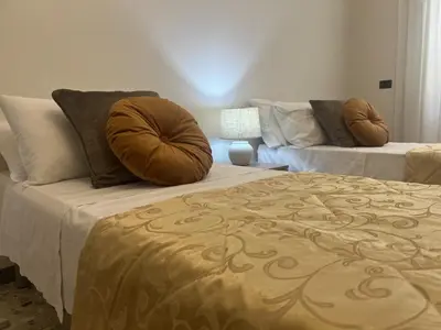 a bedroom with two beds with pillows and a couch at Luxury apartment San Giovanni in Rome