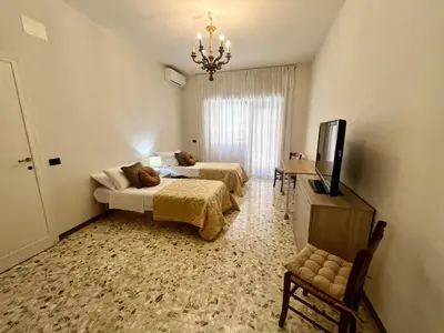 a hotel room with two beds and a television at Luxury apartment San Giovanni in Rome