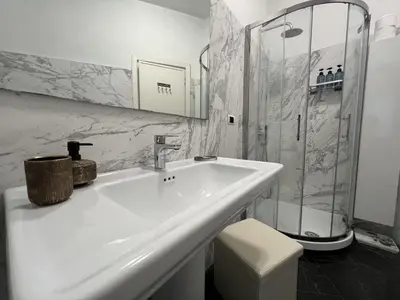 a white bathroom with a sink and a shower at Luxury apartment San Giovanni in Rome