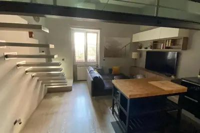 a living room with a couch and a stairway at Caffa Apartment in Rome