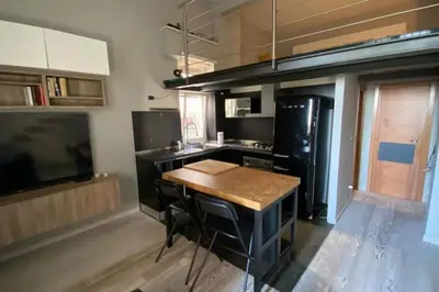 a kitchen with a table and a black refrigerator at Caffa Apartment in Rome