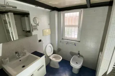 a bathroom with a toilet and a sink and a mirror at Caffa Apartment in Rome