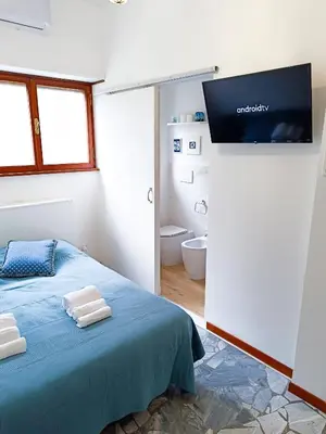 a bedroom with a bed and a flat screen tv at Betania Loft in Rome