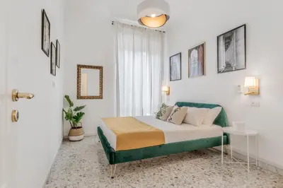 a bedroom with a bed and a green couch at Apartment Maison 170 - Rome in Rome