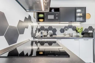 a kitchen with a black and white patterned wall at Apartment Maison 170 - Rome in Rome