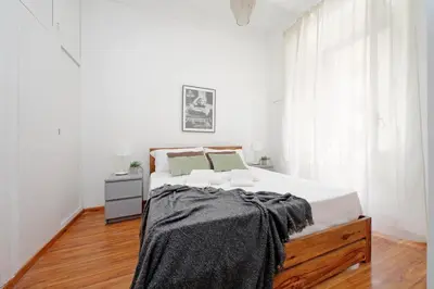 a white bedroom with a large bed and a window at Testaccio - Pretty Apartment in Rome