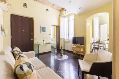 a living room with a couch and a tv at Hostly-Urban Oasis Turati-Few Steps from Colosseum in Rome
