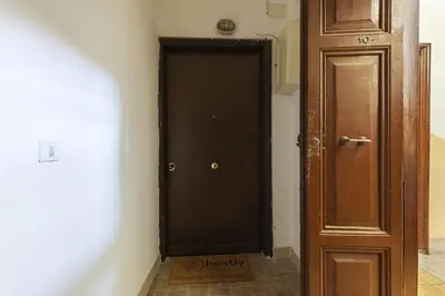 a black door in a hallway next to a wooden door at Hostly-Urban Oasis Turati-Few Steps from Colosseum in Rome